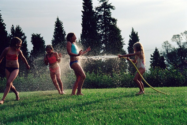 Girls playing with a hosepipe